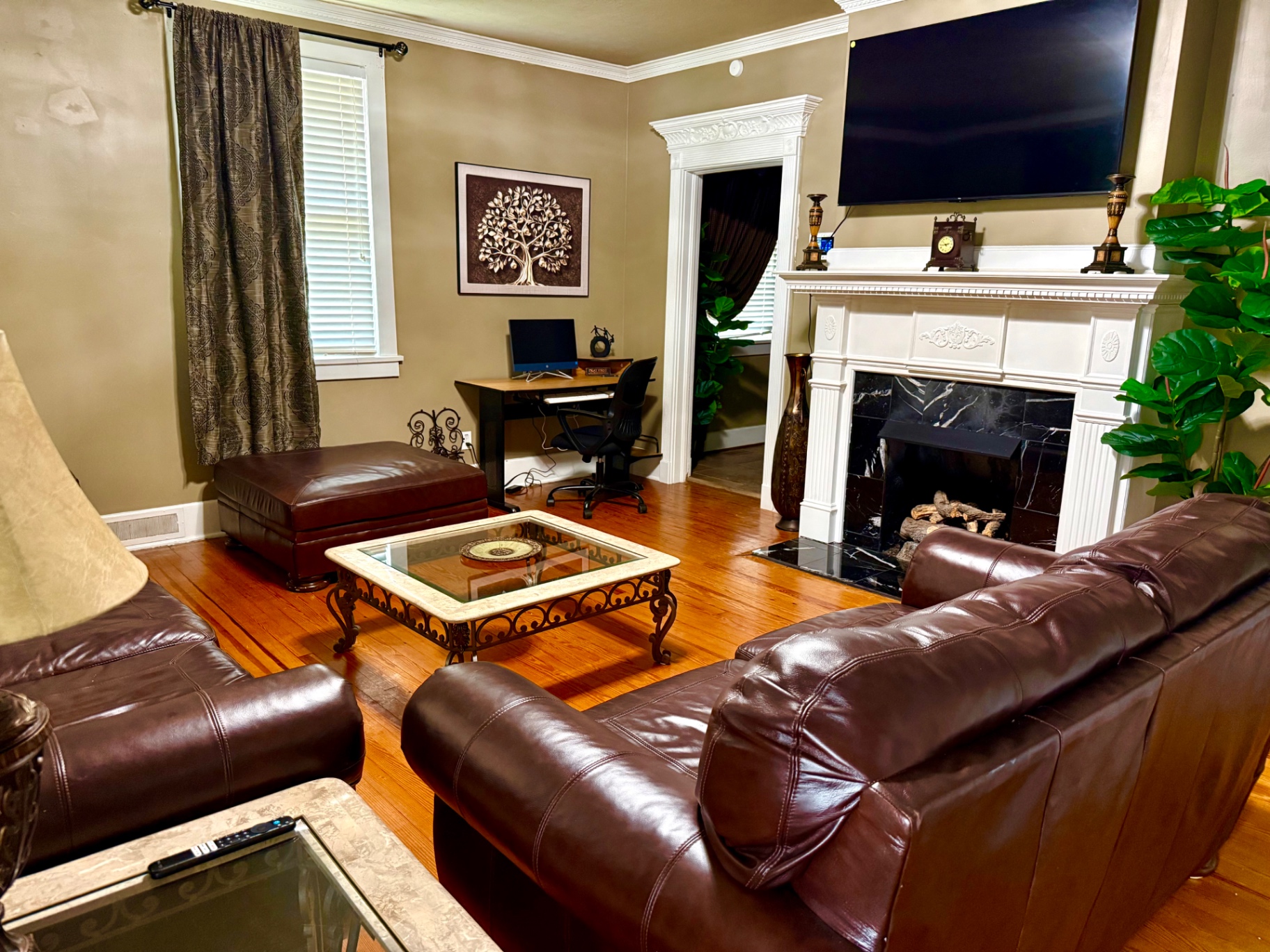 The Genesys House living room with leather sofas, fireplace, and a quiet workspace